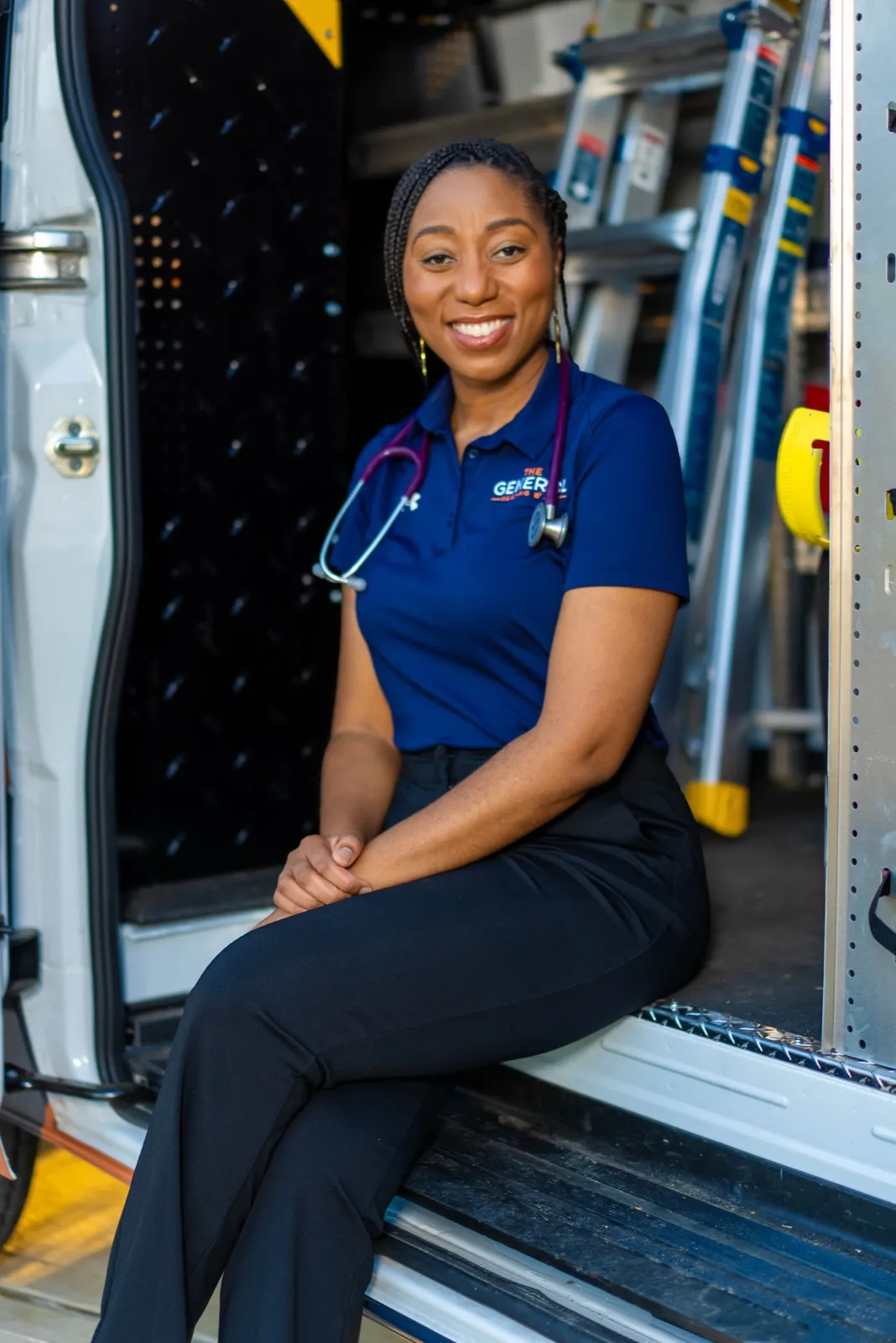 La Toya Luces-Sampson, MD, co-founder and board-certified physician, seated in The General service van with a stethoscope