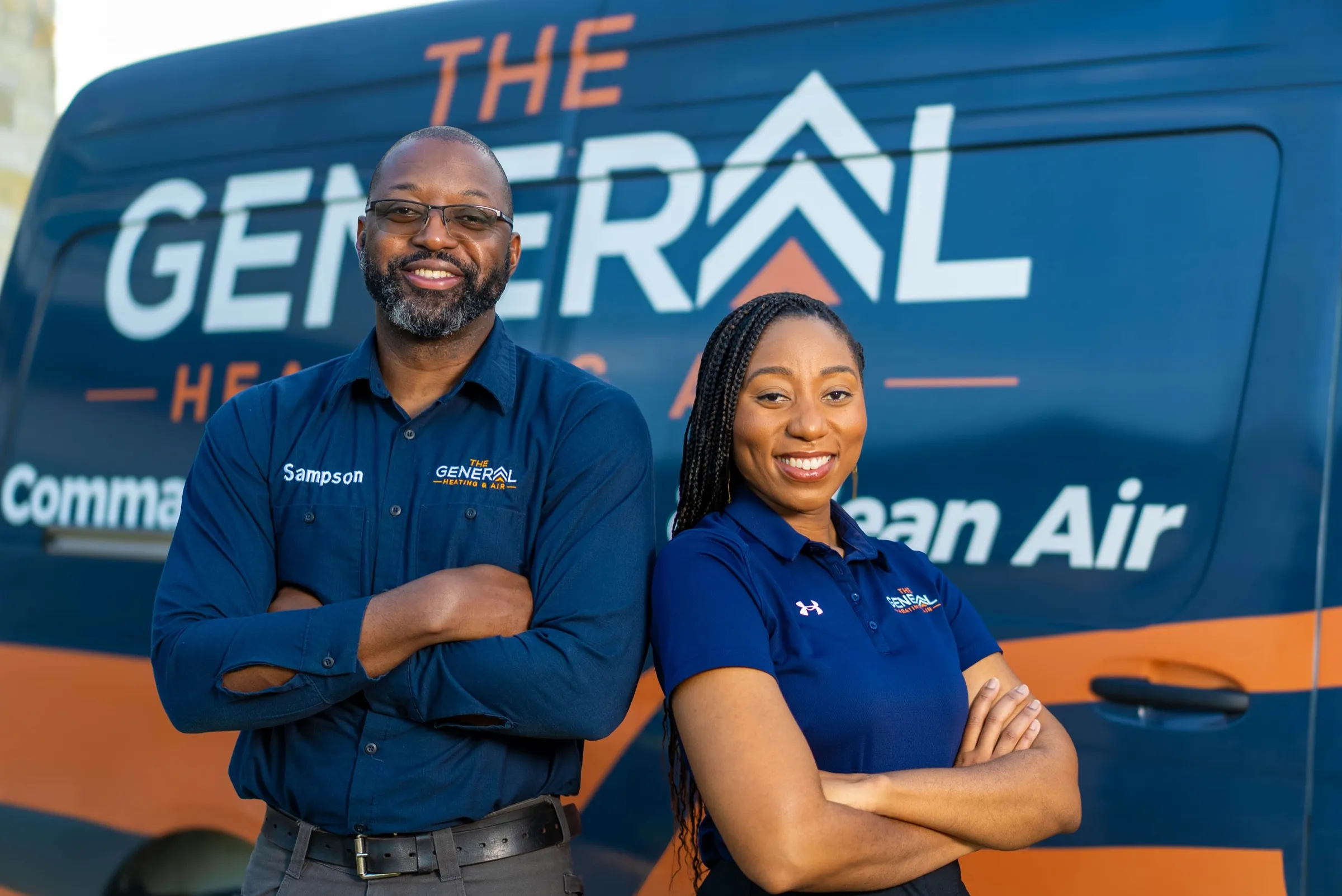 Adé Sampson and La Toya Luces-Sampson, MD, co-founders of The General Heating and Air, standing in front of their service van